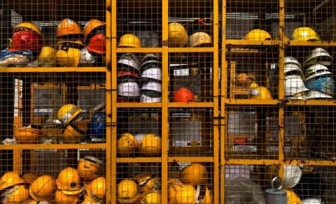 shelving full of multicolored hard hats symbolizes safety in construction site management