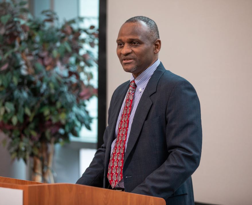 Dr. Bill Butler speaking at podium during an event.